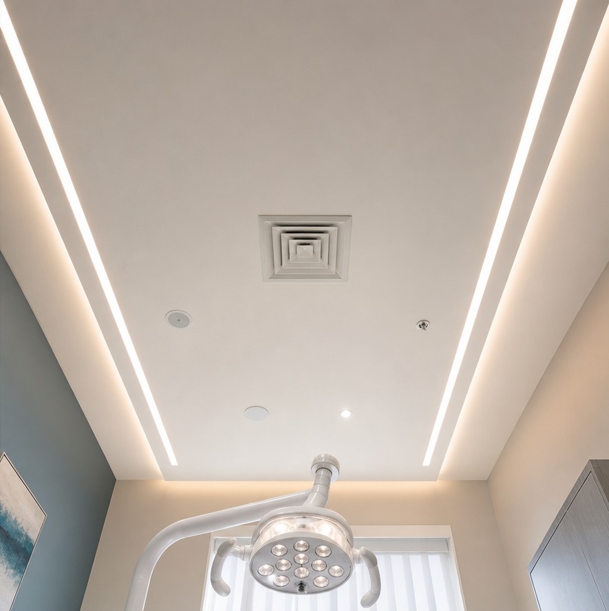 Clean stretch ceiling with integrated lighting and ventilation above a dental treatment chair